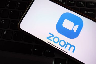 KONSKIE, POLAND - 17 Eylül 2022: Ofisteki akıllı telefon ekranında zoom logosu görüntülendi. Zoom Video Communications, Inc. bir Amerikan iletişim teknolojisi şirketidir.