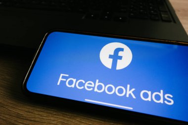 KONSKIE, POLAND - 17 Eylül 2022: Facebook reklamları ofisteki akıllı telefon ekranında gösteriliyor