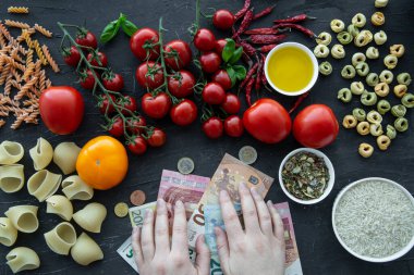 Ekonomik kriz ve günlük masrafların yüksek maliyeti. İtalyan makarnası ve Euro banlnotları kadın eli, üst görünüm. 