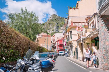 19 Nisan 2019 Taormina, İtalya. Kasabanın tarihi merkeziydi. İnsanlar yürüyor ve arka planda dağ var.. 