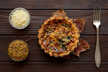 Tasty baked mini vegetable pie on wooden rustic table, top view.