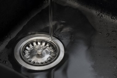 mat siyah mutfak lavabosu ve içine su aktığı metal drenaj