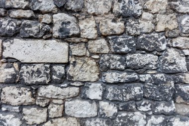 Farklı boyutlarda ve şekillerde gri doğal taştan yapılmış eski harap duvarcılık. Tasarım için arkaplan.