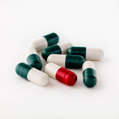 Kapsül biçimindeki çok renkli hapların bir kaç parçası beyaz arka planda izole bir şekilde yatmaktadır. Hızlı seçim için kırpma yolu var. Desing için.