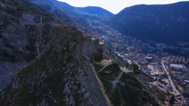 Dik bir dağın tepesindeki eski kale Vadi 'deki kasabaya karşı