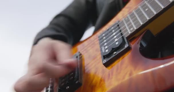 Guitarrista toca solo en el instrumento usando pick en concierto — Vídeo de stock