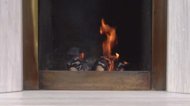 Ev şöminesinde sıcacık bir ateş. Sonbahar ve kış Noel tatili. Yanan odunların alevleri, yaklaşın. Ev konforu