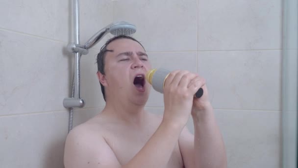 感情用事的体形丰满的男子在当代浴室里用黄金话筒洗澡，唱卡拉OK — 图库视频影像