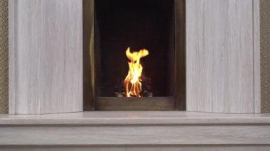 Evinde yanan parlak bir odun bulunan klasik taş şömine. Yanan odunların alevleri, yaklaşın. Soğuk kış gecesinde kamp ateşinde yanan ağaçlar