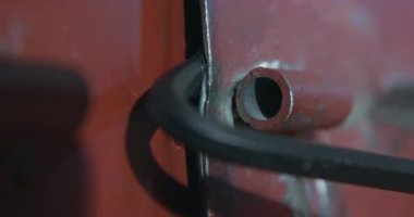 Hırsız, metal levye yardımıyla depo kapısını açıyor.