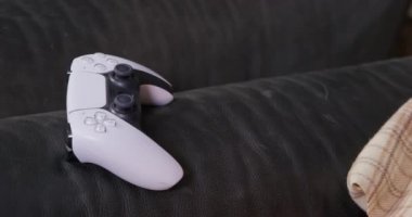 Adam kablosuz kontrol cihazını koltuğun kolluğundan alıyor.