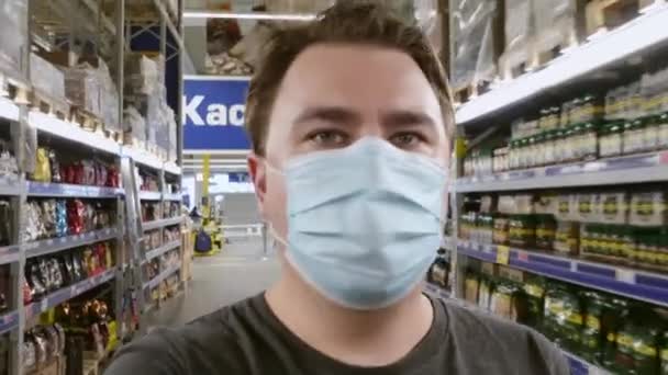 Молодий чоловічий блогер в захисній масці розмовляє з камерою телефону — стокове відео