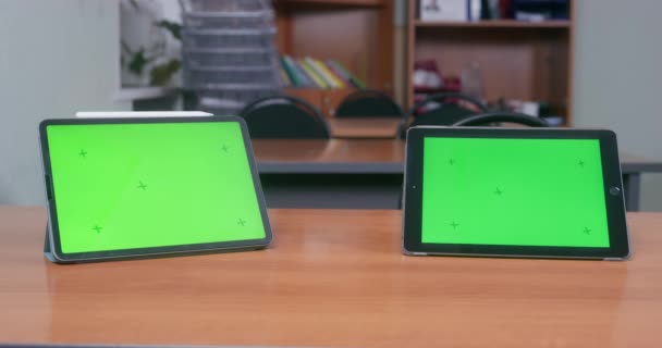 Twee tabletten met groene schermen op het bureau van de school — Stockvideo