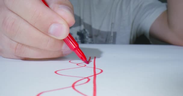 Persoon tekent grafiek lijn of patroon voor nieuwe project ontwerp met een rode felt-tip pen, front view, macro-opnamen met gemotoriseerde camera slider in de studio. Student werkt aan project en doet huiswerk — Stockvideo