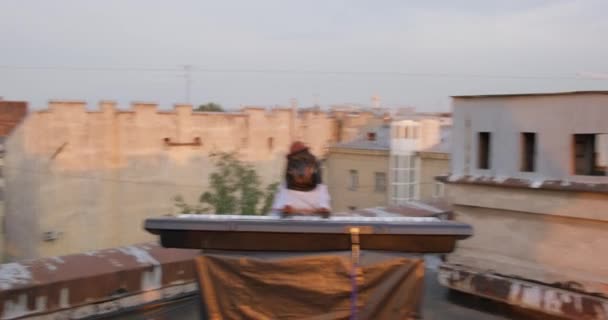 La banda de rock adolescente organizó un concierto al aire libre en el techo. Chicos saltar, tocar guitarras y cantar expresivamente, dachshund toca sintetizador, cámara se mueve de uno a otro más rápido y más rápido, girando alrededor del eje — Vídeo de stock