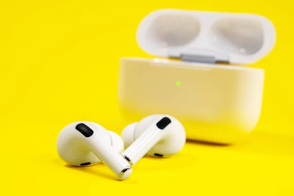 Rostov, Rusia - 06 de julio de 2020: Auriculares inalámbricos Apple AirPods Pro en caja de carga abierta con sonido inmersivo de cancelación de ruido activo, sobre fondo amarillo, espacio para copiar — Foto de Stock