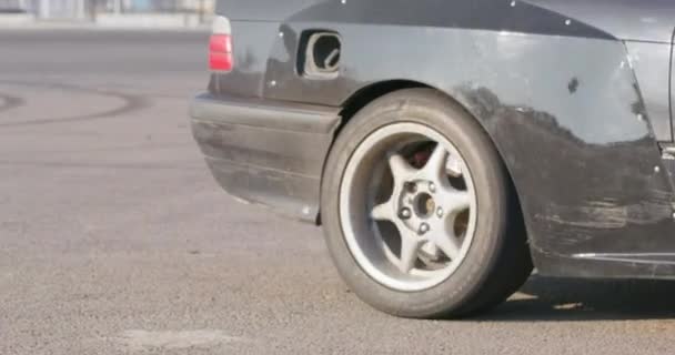 Tuned black drift car with worn out wheel drives away — Stock Video