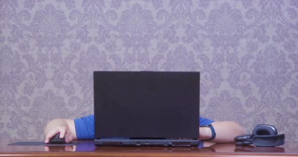 Pummeliger Mann blickt auf modernen Laptop auf Holztisch — Stockvideo
