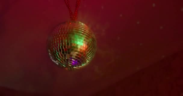 아름답게 돌아가는 반짝 이는 거울 디스코 볼 이 연기 가운데있는 방 천정에 무겁게 달려 있다. 밤의 역습 파티의 개념 — 비디오