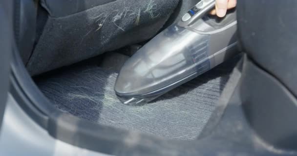 男人在车里擦黑色的纺织品垫，去除狗毛 — 图库视频影像