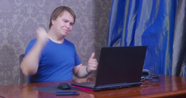 Plump man gets late looking at time near computer at table — Stock Video