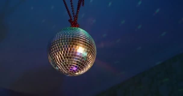 Person rotates beautiful rotating sparkling mirror disco ball weighs on the ceiling in the room in the smoke. Concept of night retro party — стоковое видео