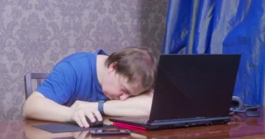 Sleepy man gets tired working on computer in office room