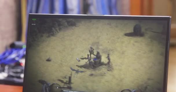 Rostov, RUSSIA - November 13 2021: Laptop screen on which gamer plays online game Diablo 2 Resurrected with friends over Internet, front view. Character is killed and guy throws up hands indignantly — стоковое видео