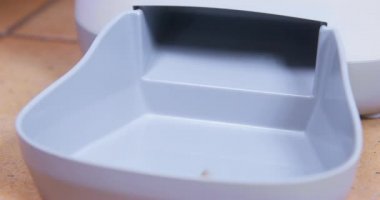 Kuru gıda topakları plastik tepsi içinde otomatik evcil hayvan besleyici makineye dökülüyor, kapatın. Hayvanları zaman ve zamana göre beslemek için bir aygıt