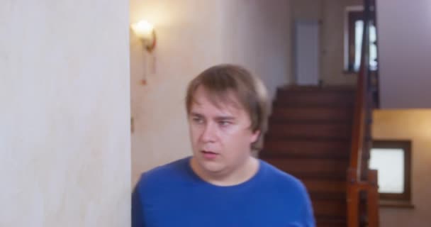 Pulchny człowiek biegnie w pokój w pośpiechu potrząsając głową przez schody — Wideo stockowe