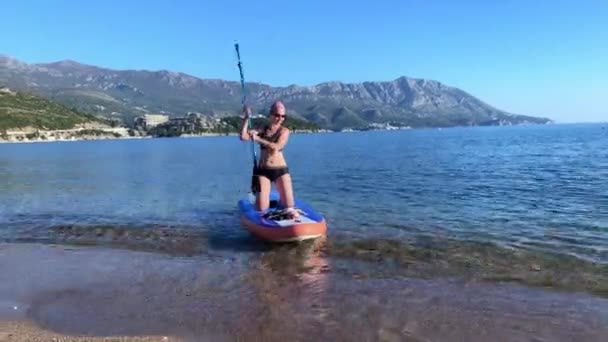 Frau genießt SUP-Boarding am Strand der Adria — Stockvideo