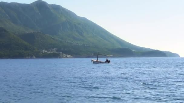 Pequeno barco de pesca navega no mar Adriático contra montanhas — Vídeo de Stock