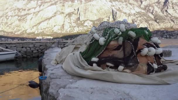 Αλιευτικό δίχτυ βρίσκεται στην προβλήτα πέτρα στο λιμάνι κατά των βουνών — Αρχείο Βίντεο