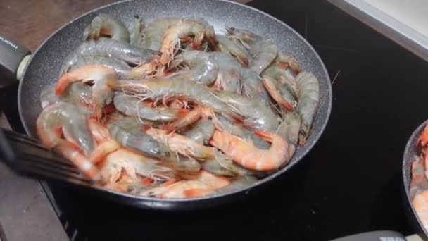 Pommes rohe Garnelen auf Pfanne am modernen Herd in der Küche kochen — Stockvideo