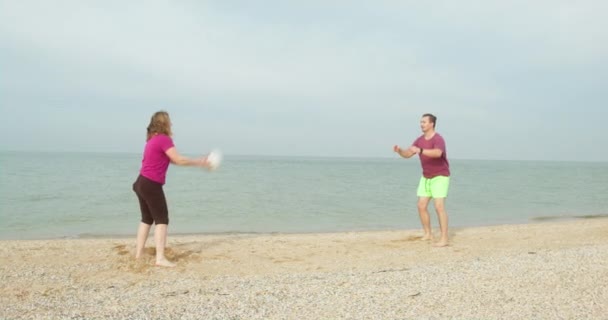 Uomo e donna giocano a beach volley su sabbia bianca vicino al mare — Video Stock