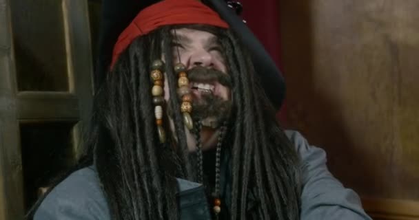 Gekke piratenkapitein lacht bij ramen in hut — Stockvideo