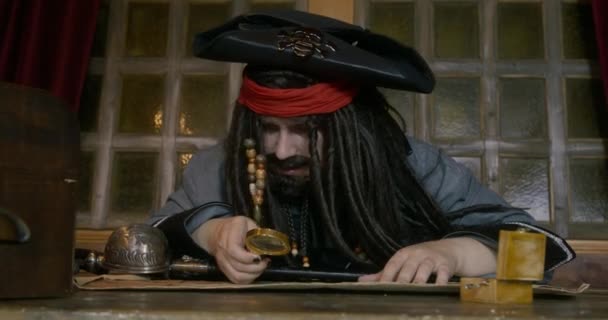 Пірат дивиться через Лупе на карті, шукаючи скарби — стокове відео