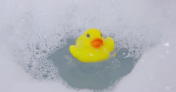 Anatra di gomma in acqua di vasca da bagno con strato spesso di bolle — Video Stock