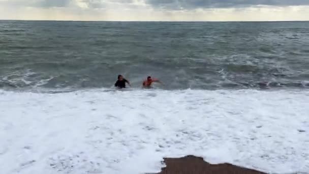남자가 폭풍중에 바다에서 수영을 하다가 이제그 해변으로 올라오려고 애쓰고 있지만 — 비디오
