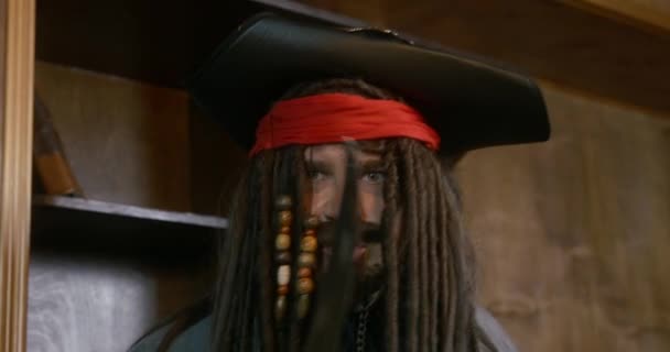 Crazy piraat kapitein schudt met sabel tegen houten rekken — Stockvideo