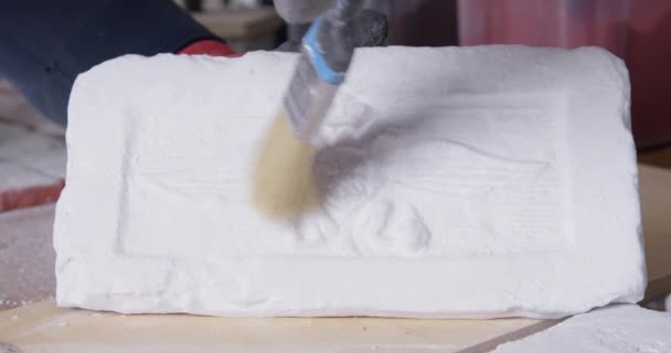 Homem varre poeira de molde de gesso para fundição para ver padrão — Vídeo de Stock