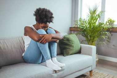 Yan görünümü genç kadın evde kanepede oturan pencere uzak bakıyor. Hayal kırıklığına uğramış karışık erkek erkek veya beklenmeyen gebelik kavramı ile ayrılmak mutsuz sorun kişisel hayat kavga hissediyor