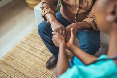 Genç bir kadının, yaşlı bir adamın ellerini rahatça tutarken yakın plan fotoğrafı. Üst düzey bir adam ve bir hemşirenin el ele tutuşması. Sadece bakıcı değil, aynı zamanda sırdaşımdır.