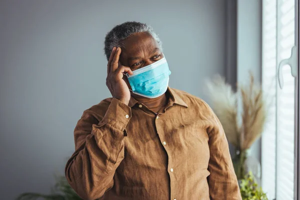 Starší Afroameričan Ochrannou Obličejovou Maskou Doma Dívá Oknem Koncept Koronavirové — Stock fotografie