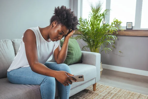 Depressed sad attractive woman crying on sofa couch at home feeling lonely tired and worried suffering depression in mental health, loneliness and isolation concept. Psychology, solitude and people