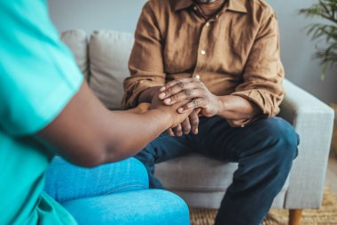 Huzurevinde yaşlı adamın elini tutan hemşire. Doktor yaşlı hastaya Alzheimer hastalığı konusunda yardım ediyor. Yaşlı bir adama yardım eden bir bakıcı vuruldu. Bakım işçisi kıdemli adama yardım ediyor.