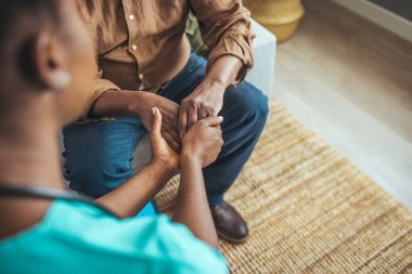 Yaşlı bir adamın elini tutan beyaz önlüklü hemşire fiziksel ya da psikolojik yardım sağlıyor, kollarını kapat. Rahatlama yalnızlığı, tedavisi olmayan hastalıklar, hemşirelik, empati