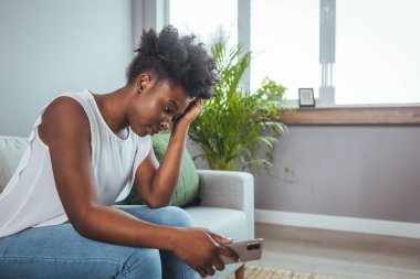 Yan görünümü genç kadın evde kanepede oturan pencere uzak bakıyor. Hayal kırıklığına uğramış karışık erkek erkek veya beklenmeyen gebelik kavramı ile ayrılmak mutsuz sorun kişisel hayat kavga hissediyor