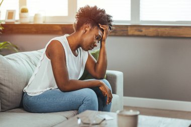 Yan görünümü genç kadın evde kanepede oturan pencere uzak bakıyor. Hayal kırıklığına uğramış karışık erkek erkek veya beklenmeyen gebelik kavramı ile ayrılmak mutsuz sorun kişisel hayat kavga hissediyor