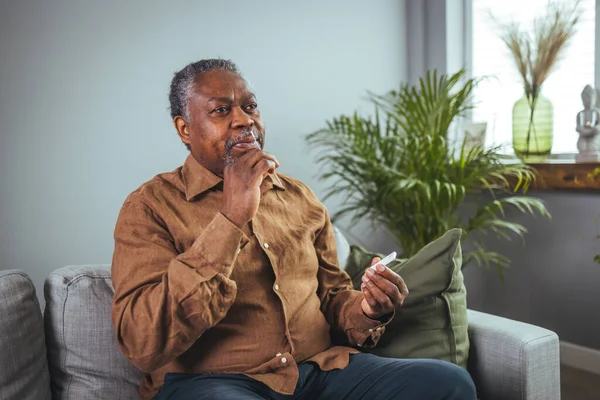 Old senior African American male hand nasal swab testing rapid tests by himself for detection of the SARS co-2 virus at home isolate quarantine concept